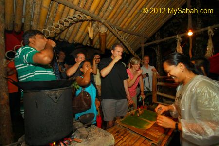 tourists try Lihing the local rice wine
