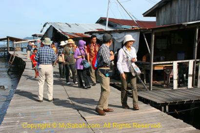 Tourists visit stilt houses