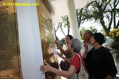 relatives looking for the name on plaque of Petagas war monument