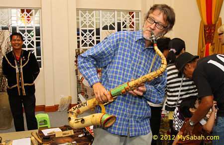 tourist playing bamboo saxophone