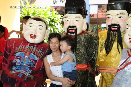 taking photo with big head Buddha and God of Wealth