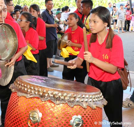 girl beating drum for lion dance