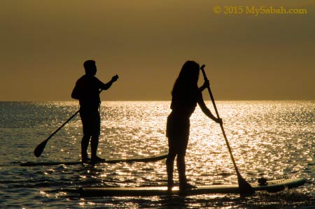 stand up paddle boarding under sunset