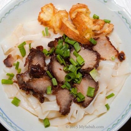 Kueh Teow noodle topped with deep-fried pork and minced spring onion