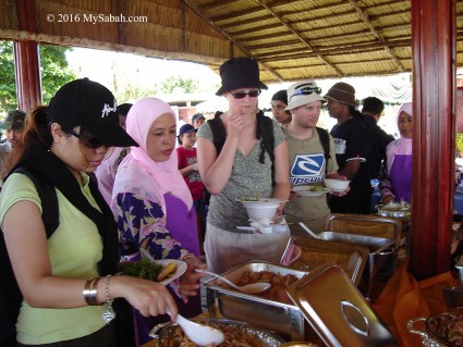 Tourists trying out Sago Grubs (Butod)