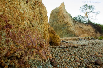 beach and hill covered by stones and pebbles