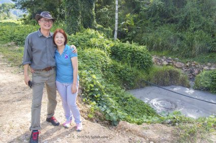 couple taking photo next to mud volcano