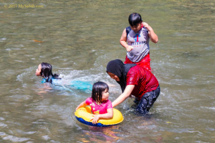family and kids swimming in river