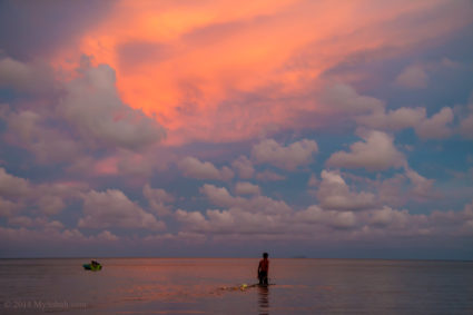 Fisherman walking to the sunset