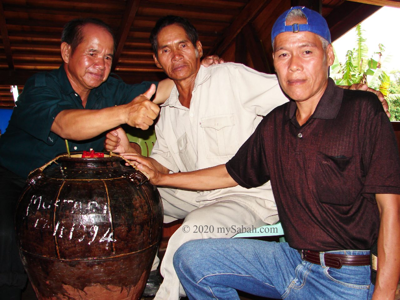 3 men next to Tapai wine jar