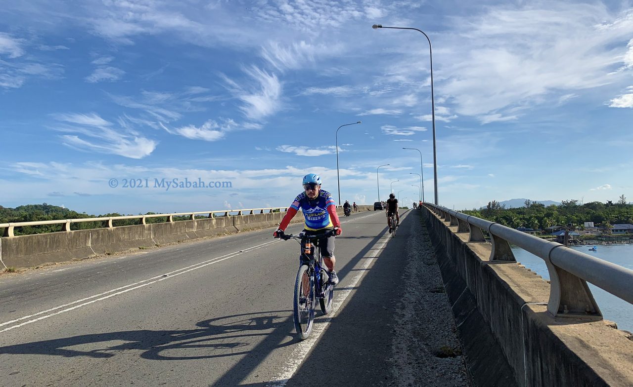 Cyclists crossing the Mengkabong River Bridge