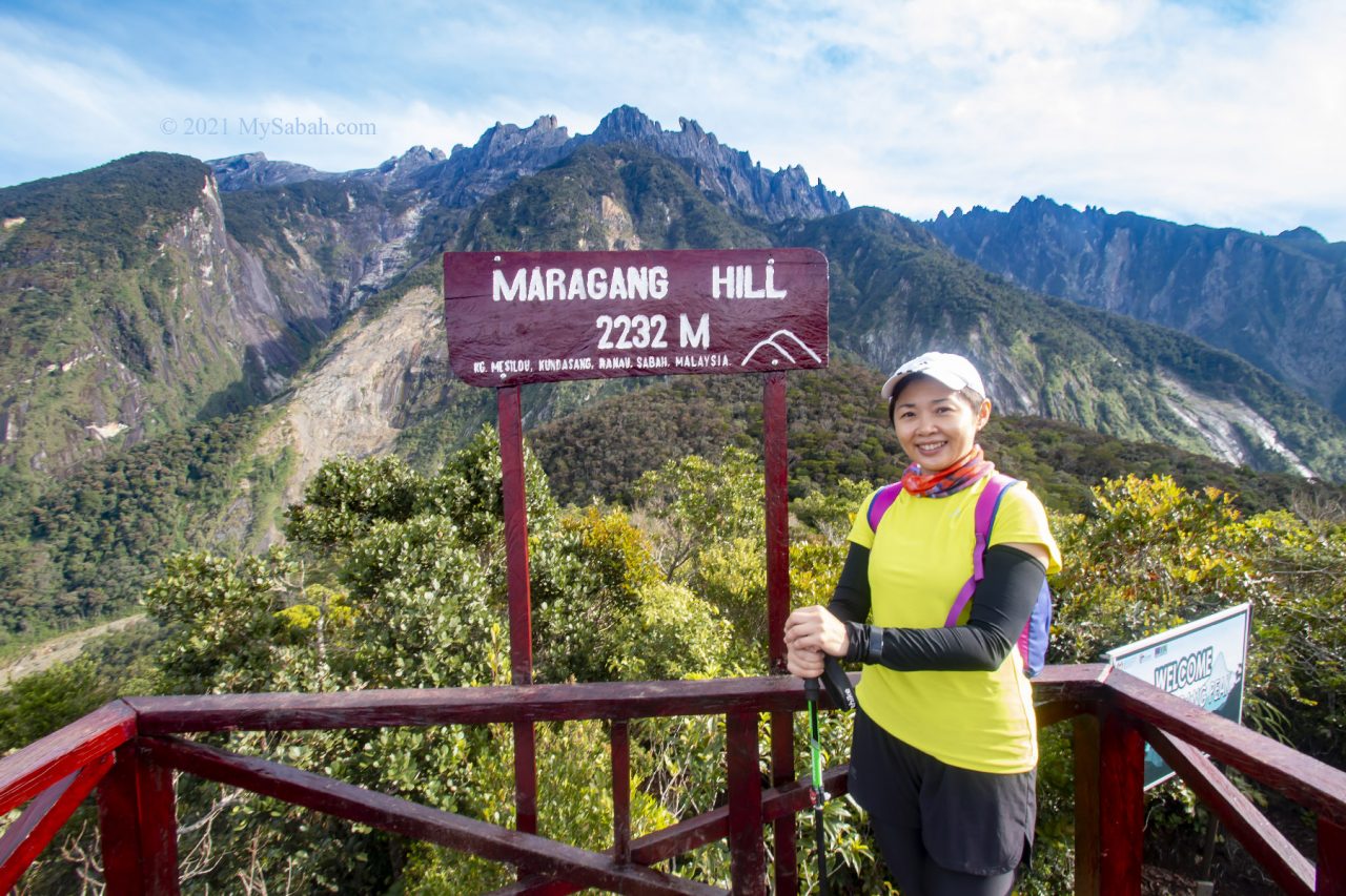 Girl taking photo next to the summit signage of Maragang Hill
