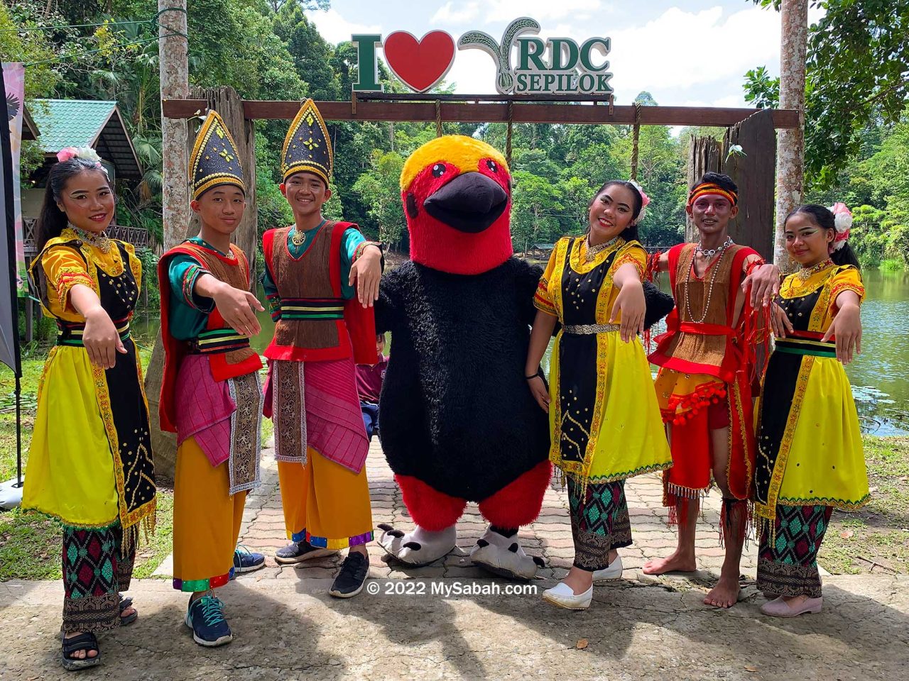 Group photo of Bornean Bristlehead mascot and Sabah natives