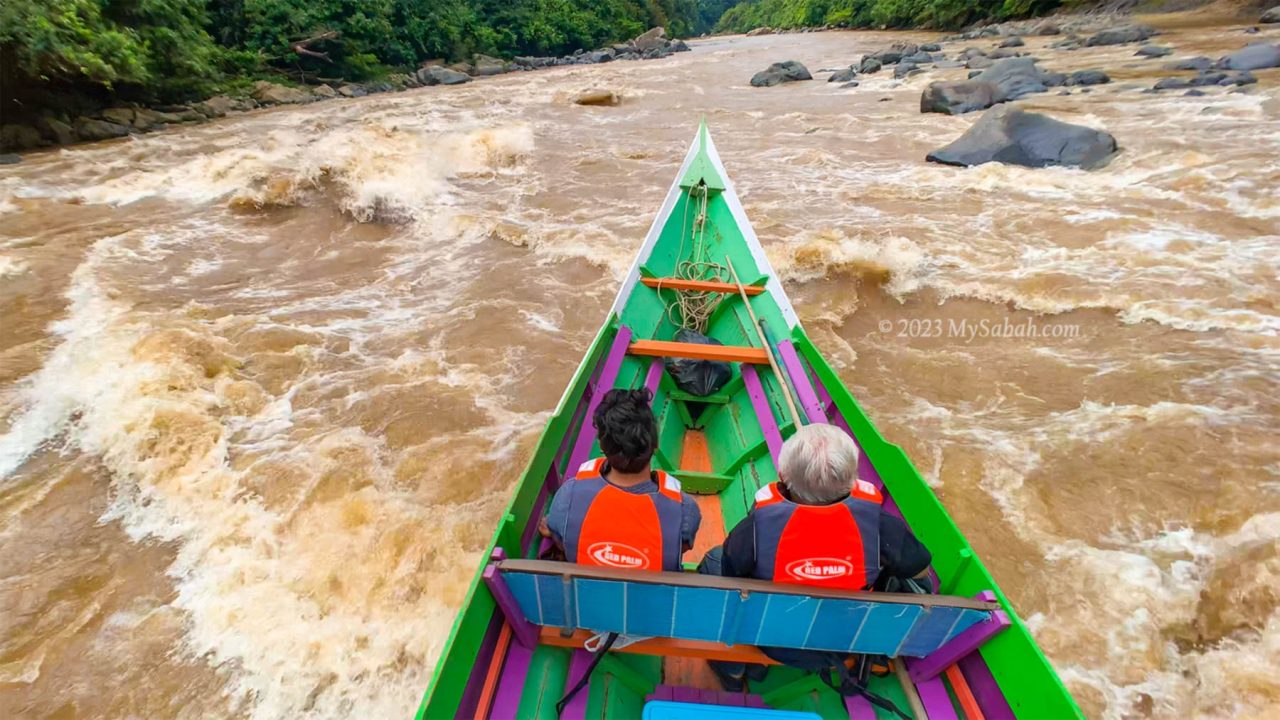 Long boat cutting through the strong rapid