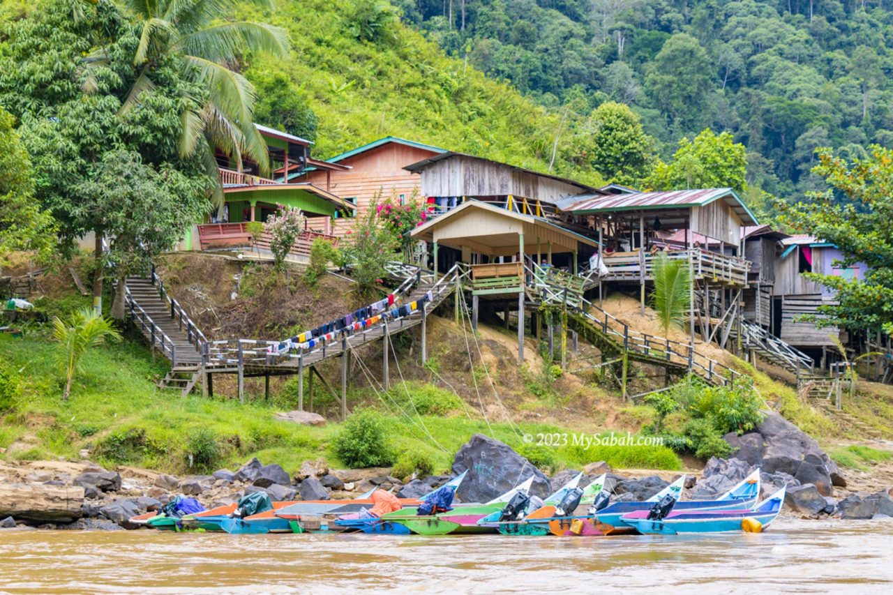 longhouses and boats park at the river