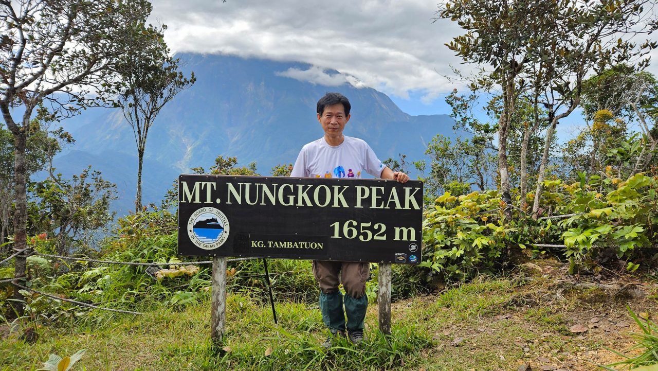 Summit signage at 1,652 m and the view of Mount Kinabalu from the peak of Mount Nungkok.